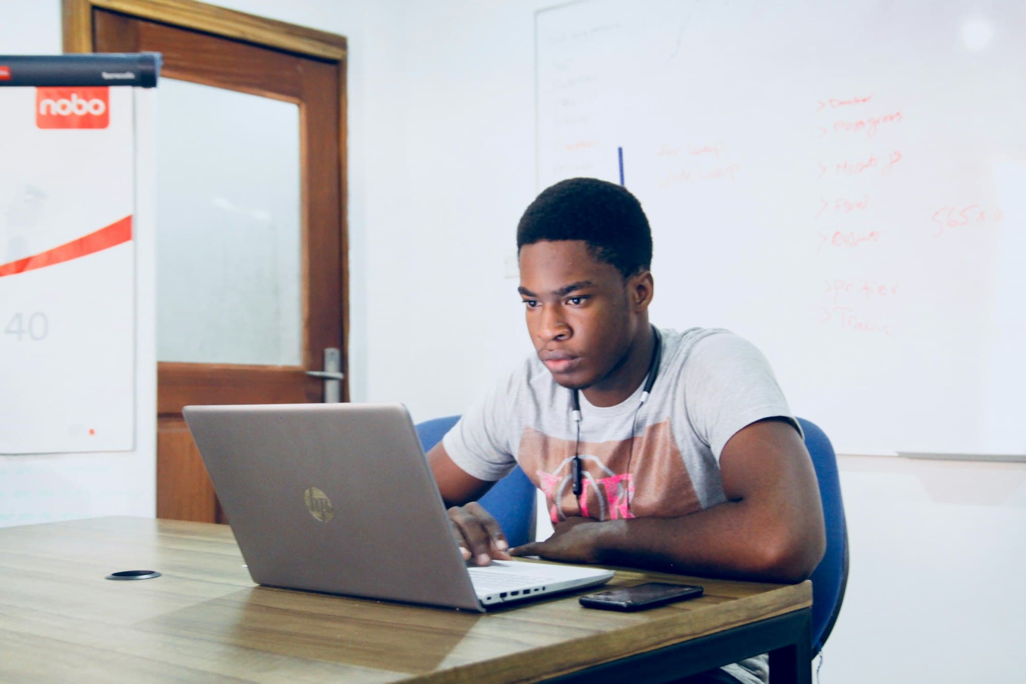 Young man concentrating on a laptop at a wooden table