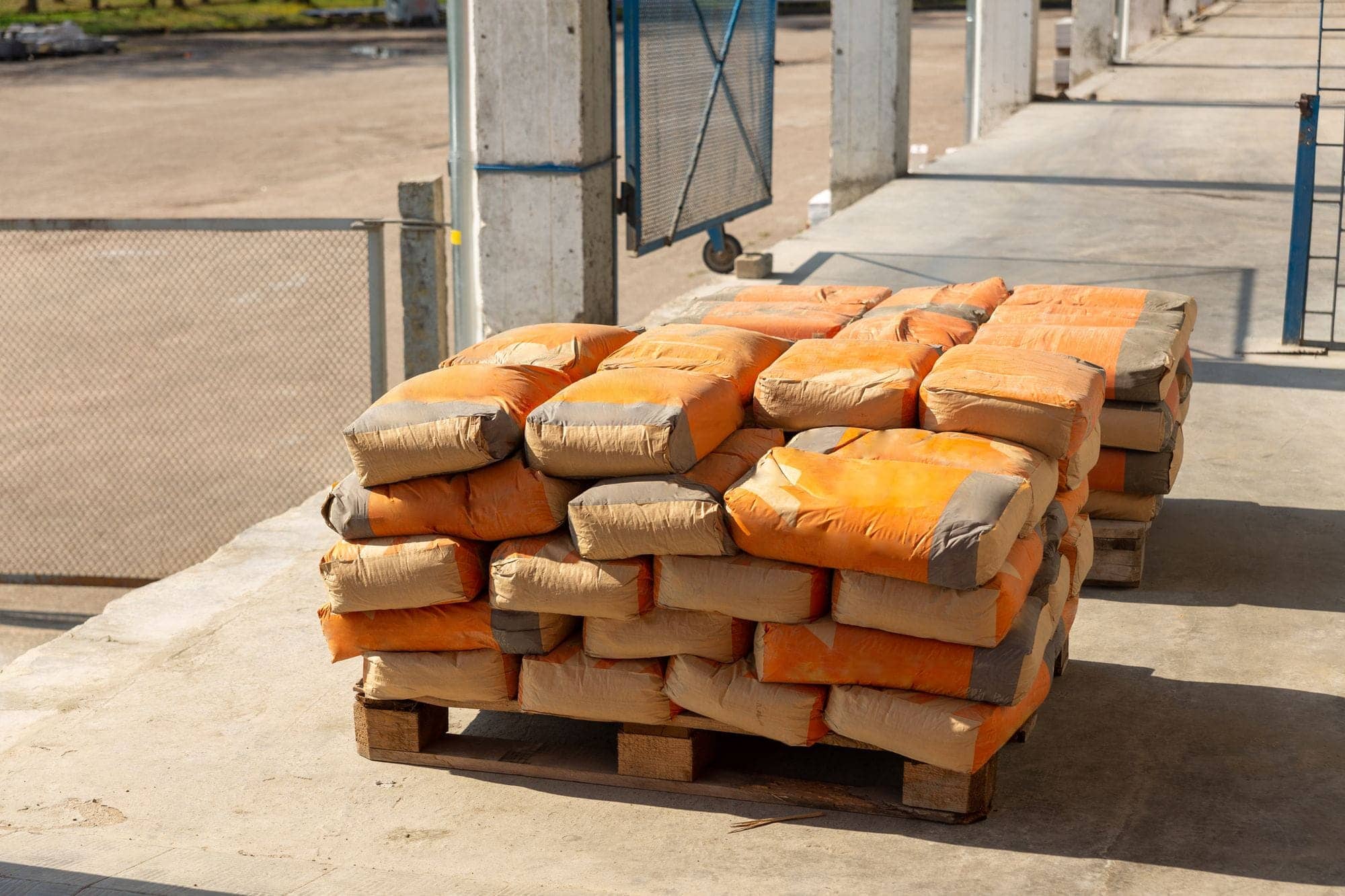 Stack of cement bags on a wooden pallet in a materials yard